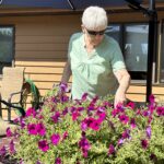 Woman watering the flowers at assisted living residence at Evergreen in Oshkosh.
